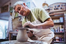Craftsperson Making Container In Pottery Workshop