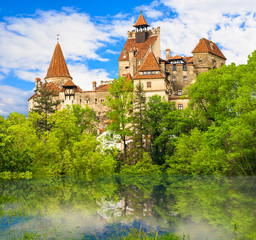 Wall Mural - Beautiful view over the medieval architecture of  Bran castle reflected in a lake