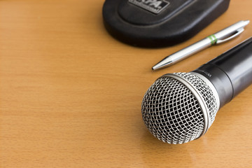 closed up microphone on wooden table, over light [blur and select focus] background]