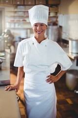 Wall Mural - Portrait of happy chef standing with hand on hip