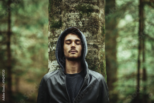 Fotografía Man leaning on a tree with eyes closed