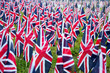 British United Kingdom UK Flags in a row with front focus and the further away symbols blurry with bokeh. The flags were set up on Memorial Day in DC. There are some American USA Flags in the back.