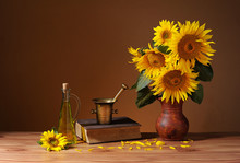 Sunflowers In A Vase, Books And Oil In A Bottle On The Table