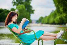 Woman In Green Dress Reading A Book In Tuileries Garden Of Paris, France