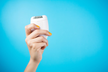 Wall Mural - Woman holding epilator against blue background