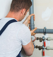 Wall Mural - Male plumber assembling water pipes.