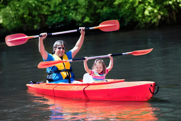 Father and child kayaking in summer