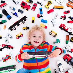 Wall Mural - Little boy playing with toy cars