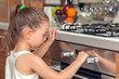 © Myst - beautiful curious little girl examining oven in kitchen