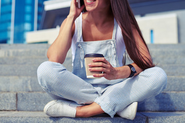 Wall Mural -  Close-up of young woman sitting with crossed legs and talking o