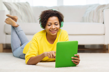 Wall Mural - happy african woman with tablet pc and headphones