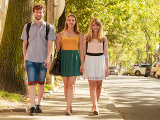 three people friends walking outdoor.