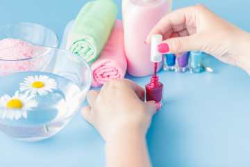  Woman makes herself manicure, on white background