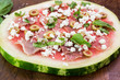 Watermelon pizza with crumbled feta cheese and prosciutto.