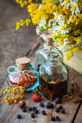 Wall Mural - Bottles of tincture and dry healthy herbs, bunch of healing herb