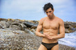 © theartofphoto - Young shirtless athletic man standing in water by ocean shore