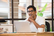 © wong yu liang - casual indian man smiling and working at office
