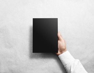 Hand holding blank black brochure booklet mockup. Leaflet mock up presentation. Pamphlet hold hand. Man show book offset paper. Sheet template. Booklet design. Paper sheet display read first person