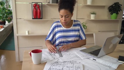 Aufkleber - African young designer works at the creative modern agency. Professional female checking architectural sketch at the working place with laptop pencil line equipment for drawing and draftsmanship. On