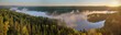 Sunrise panorama landscape at Aulanko nature park in Finland. Fog rising from the lake on misty summer morning.