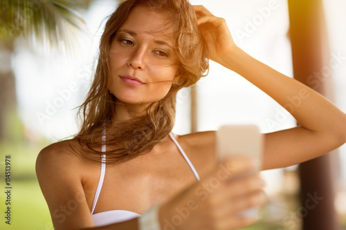Fototapeta na szkło seksowna dziewczyna robi selfie w bikini