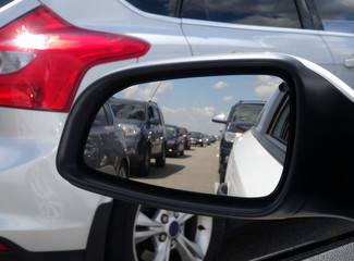 Wall Mural - Back view of cars in rear mirror in the road congestion 