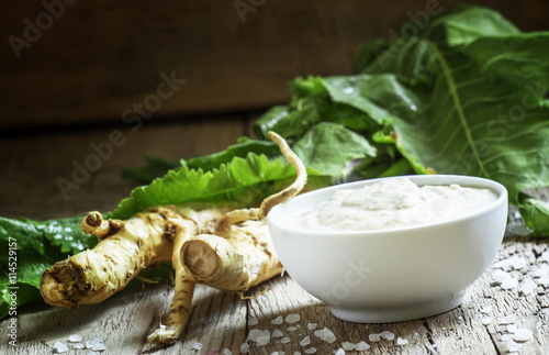 Fotografía Rábano suelo, salsa picante a la comida en un recipiente blanco, raíces