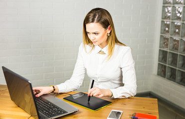 Fototapete - Young female designer using graphics tablet while working with computer