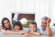 © vectorfusionart - Composite image of family in sitting room smiling at camera