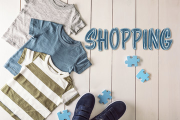 Sticker - Flat lay children clothing and accessories on wooden background. Shopping concept