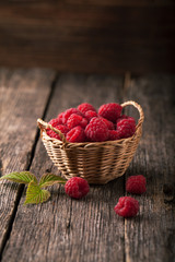 Poster - Ripe fresh raspberries with leaves in a basket