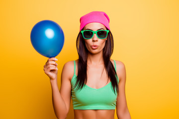 Sticker - Cheerful hipster girl in pink hat  holding balloon on yellow wal