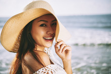 Portrait Of Pretty Woman In Straw Hat On A Beach