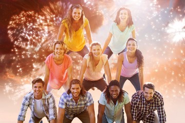 Poster - Composite image of happy friends making human pyramid