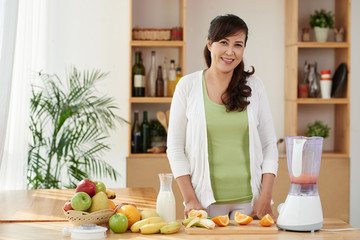 Pretty Vietnamese woman preparing healthy meal in kitchen