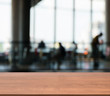Wooden empty table in front of blurred people