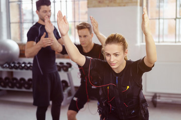 trainer und sportler beim ems-training im studio