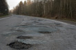Potholes on the road. Broken russian road.
