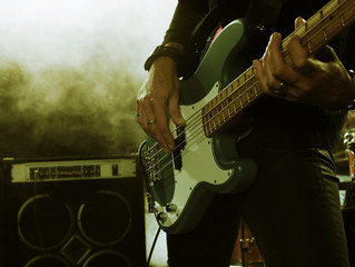 Wall Mural - Rock band performs on stage. Bassist in the foreground. Close-up.