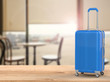© phonlamaiphoto - blue luggage with cafe background