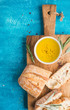 Mediterranean snacks set. Olive oil, herbs and sliced ciabatta bread on rustic wooden board