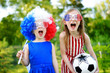 © MNStudio - Two funny little sisters supporting and cheering their national football team