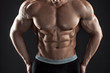 © nazarovsergey - Muscular bodybuilder guy doing posing over black background