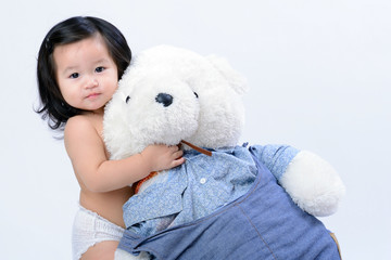 Adorable little asian girl hugging a teddy bear on white backgro