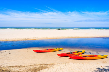 Wall Mural - Kayaks on white sand beach in Debki village where Plasnica river has its estuary to Baltic Sea, Poland