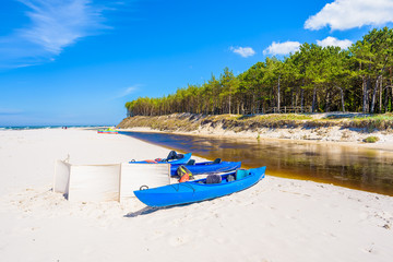 Wall Mural - Kayaks on white sand beach in Debki village where Plasnica river has its estuary to Baltic Sea, Poland