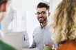 © Westend61 - Smiling businessman with colleagues analysing data