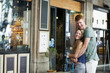 © Westend61 - Happy couple standing in front of a coffee shop