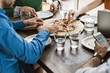 © Westend61 - Colleagues at table with cell phone and laptop having a pizza