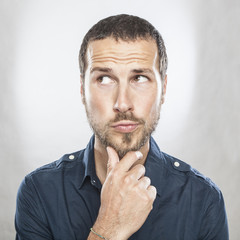 Portrait of handsome young thoughtful man isolated over white ba